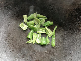 7、青椒炒香肠,旺火将青椒放入爆香，炒出呛辣香味。