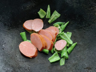 8、青椒炒香肠,将香肠片放入其中。