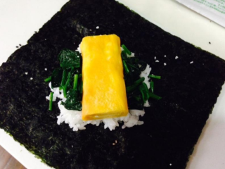 1、日式饭团,将海苔平放,上面先铺上一层饭, 再依自己的设计放上任何材料