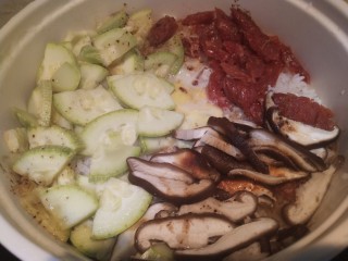 8、家常腊肠西葫芦香菇三拼煲仔饭,调好的酱汁沿着锅边淋入,再盖盖焖2-3分钟就可以出锅了