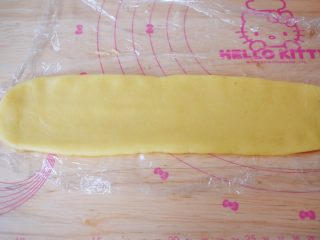 11、豆沙一口酥,取一份面团，放入保鲜膜上，再用擀面杖轻轻擀成长方形，长度大概在25CM左右