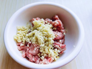 3、自制蒜香脆皮肠,将切好的姜蒜末放入肉麻中。