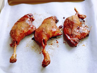11、孜然烤琵琶鸭腿,将鸭腿放在垫有油纸的烤盘中，均匀的撒上孜然粉。