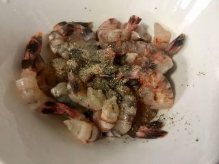 3、炸虾球,准备适量的虾去掉头部,把虾壳刨去留下小尾巴,然后用牙签挑去虾线,处理干净后清洗并沥干水分,再加入少许的料酒或者朗姆酒,盐和少许的黑胡椒粉腌制15分钟