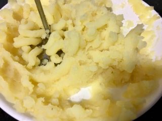 6、炸虾球,用两个大土豆切成片再锅里蒸熟,压成泥,然后用筛子过筛一遍,这样土豆泥的口感更细腻柔软,加入黄油混合均匀,然后搓成一个个均匀的小球