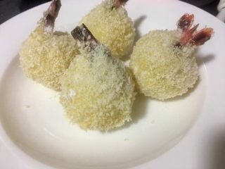 11、炸虾球,然后将蘸好淀粉的虾球再放入鸡蛋液碗中蘸满鸡蛋液,再粘上面包糠就好了,全部做好备用