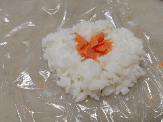 3、剩米饭百种做法+小老鼠抱蛋煎饭团,保鲜膜裹住一勺米饭，中间夹火腿粒