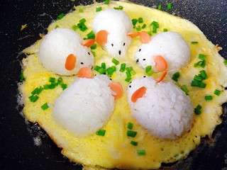 16、剩米饭百种做法+小老鼠抱蛋煎饭团,香味飘出，蛋基本凝固时，沿锅边再次放入少量油，撒上葱花