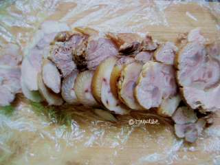 8、水晶肘花,炖好了让它自然冷却，不烫手温热的时候把线拆了，然后用保鲜膜卷紧！一定要卷紧，成功与否就在于你卷没卷紧，完全冷却放入冰箱冷藏室，第二天拿出来切片