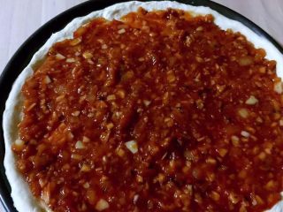 10、至尊披萨,发酵好的面，擀成面饼，面饼周边稍后，用叉子在面饼上扎一些小孔，静止15分钟后刷上番茄蒜蓉酱（这是9寸批萨盘）