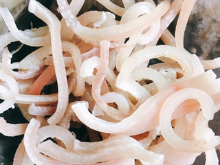 5、猪皮泡菜炒年糕,猪皮汆水3分钟后捞出，刮去多余的油脂切成丝。