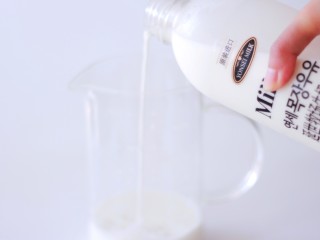 1、承味延世牛奶芒果布丁,撕开封口贴，把牛奶倒入量杯中