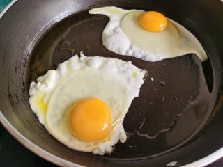 3、芝士火腿三明治,鸡蛋打入锅里两面煎熟。