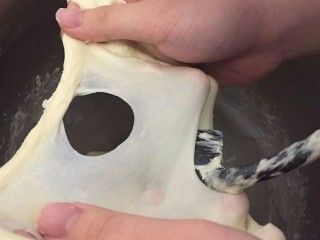 6、蒜香香肠热狗面包,撤出薄膜，洞口像这样光滑的就可以停手了。