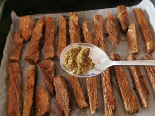 13、手撕牛肉干,码放到烤盘中 撒上孜然粉