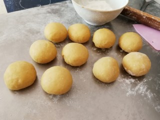 8、豆沙小面饼,放到面板上面  轻柔排气  分成10份
