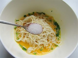 4、面条鸡蛋饼,将面条放入鸡蛋液里,饼加适量的盐、胡椒粉
