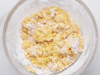 5、南瓜小圆子,加入糯米粉，跟和面一样，用筷子先搅成絮状，再上手揉成光滑的面团。