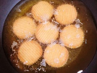 16、南瓜糯米薯片饼,锅中热油，油热至6成热度时，放入薯片饼。中小火煎至2分钟。