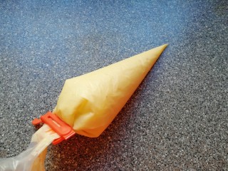 7、椰香小蛋糕,搅打好的蛋糕糊装进裱花袋，用夹子夹好口。