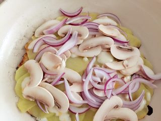 6、培根蘑菇薯片薄饼,盖上锅盖,煎至土豆已稍有变色,撒入紫洋葱和平菇(如果发现边缘土豆有焦黄的感觉,可在下面垫入一篇多出来的土豆)