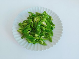 2、香辣小黄鱼,青辣椒去蒂对半切开，切成细丝。