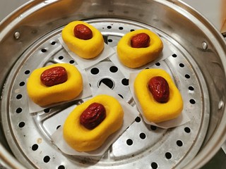 15、南瓜糯米糕,蒸锅水烧开 将南瓜糕胚摆放到蒸屉上  每个南瓜糕胚底下铺一片烘焙纸 蒸15分钟 蒸熟