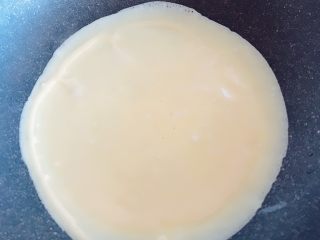 5、紫薯鸡蛋卷,锅中加入一点点油不要多 从中间部分倒入面糊 然后顺时针转动锅 是面糊均匀