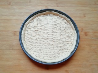 7、培根肉披萨,用叉子扎上小孔，防止饼皮在烤制的过程中凸起，做好的饼底静置15分钟左右进行二次发酵。