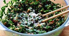 3、韭菜切肉水煎包,将肉丁和韭菜碎一起放进大盆、面发好下剂准备包包子之前，加入盐、鸡精、少许糖