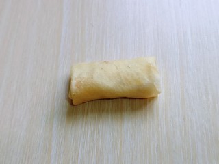 5、快手早餐～少油版香煎肉松春卷,再将两边对折，卷起来收口朝下粘住即可。