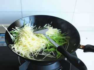 14、土豆丝卷饼,下入土豆丝继续翻炒10秒钟。