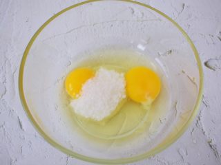 3、芒果班戟,鸡蛋打入容器中，加入白糖，用手动打蛋器搅打均匀