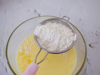 5、芒果班戟,再筛入低筋面粉，再次搅拌均匀，这时搅拌后会有颗粒状，不用担心，因为后面要过筛的