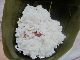 6、五花肉棕,再放入一勺米，用勺子压实