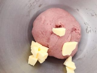 3、猪猪椰蓉小面包,搅打成光滑面团后，放入室温软化的黄油，继续低速搅打，黄油和面团融合后，厨师机高速打发。