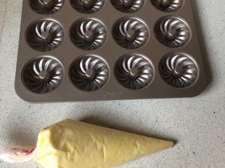 5、柠檬味小蛋糕,把面糊装入裱花袋！前面剪个小口，挤入模具，9分满