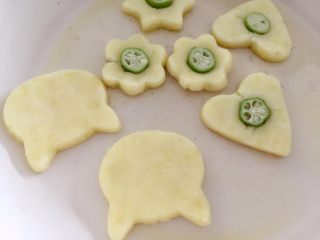 10、秋葵土豆饼,在土豆饼中间用手轻轻搓个痕迹,然后放入一小段秋葵即可。