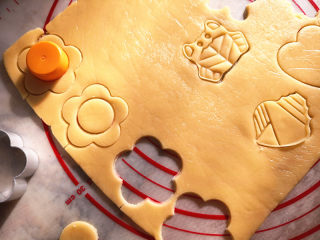 8、玻璃糖饼干,取出定型好的面片,用饼干模具按压出喜欢的花纹,做玻璃糖饼干,需要在饼干中间按出一个洞,这里我用了瓶盖,