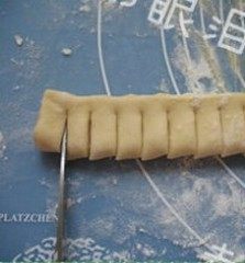 6、菠萝派,（将铺盖在上方的面片表面撒点面粉，防沾）。对折，用剪子剪出条纹。