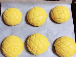 21、菠萝面包,轻轻的盖在发酵好的面团上面,皮的大小自己掌握好,皮只要盖住裸露的面团即可。刷上蛋液。