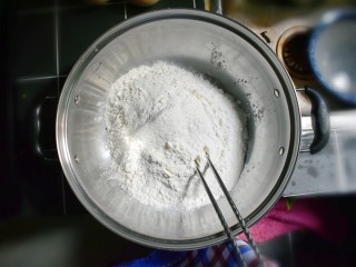 3、奶香葡萄干小面包（电饭锅版）,将面粉倒入一个大的容器中。