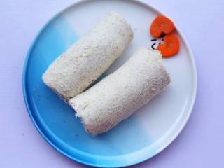 9、简单又快手的紫薯香蕉土司卷,从土司一边将香蕉紫薯泥裹紧。