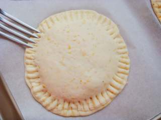 12、全麦烤馅饼,移入烤盘中，再盖上一片面片，周边用叉子压出纹路粘合。