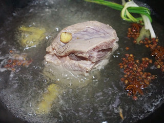 2、烧白,将五花肉皮上的毛烧掉，用刀刮去焦黄的地方清洗干净，锅内倒清水，加料酒、部分花椒粒、姜片、葱节，下入清洗干净的五花肉煮断生