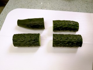3、清爽拍青瓜,把一根青瓜去头去尾，切成四段。