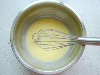 2、琵琶烧果子,蛋黄和炼乳充分混合，搅拌均匀。