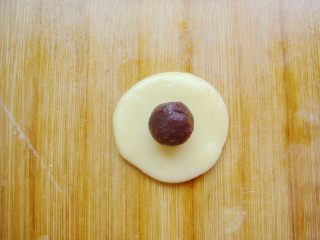 7、琵琶烧果子,取原色8克左右的小剂子擀薄片，放上适量的豆沙馅儿。