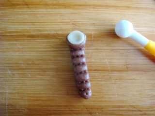 15、琵琶烧果子,原色面团搓米粒大小，捏成薄片，放到顶端处，轻压几下。做琴头。整理形状，琴颈变细长一点。