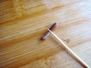 18、琵琶烧果子,取可可面团搓小一点的长条，一分为二，成豆粒大小做弦轴。